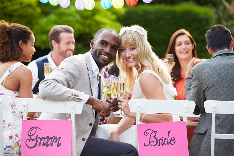 Bride and groom smiling at destination wedding reception with friends